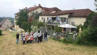 Pflegeheimbewohner winken Kita-Kindern nach ihrem Auftritt auf der Wiese am Pflegeheim HAUS BURGBLICK