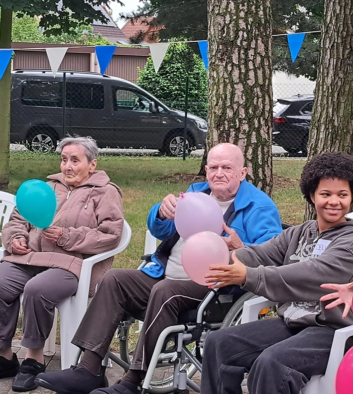 Senioren und Schüler bei einem Spiel mit Luftballons