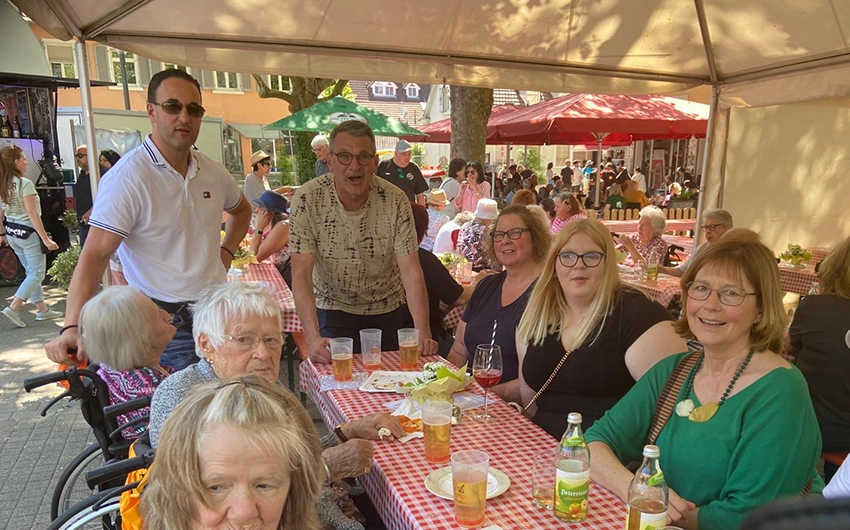 Menschen an einer Bierzeltgarnitur im Festzelt